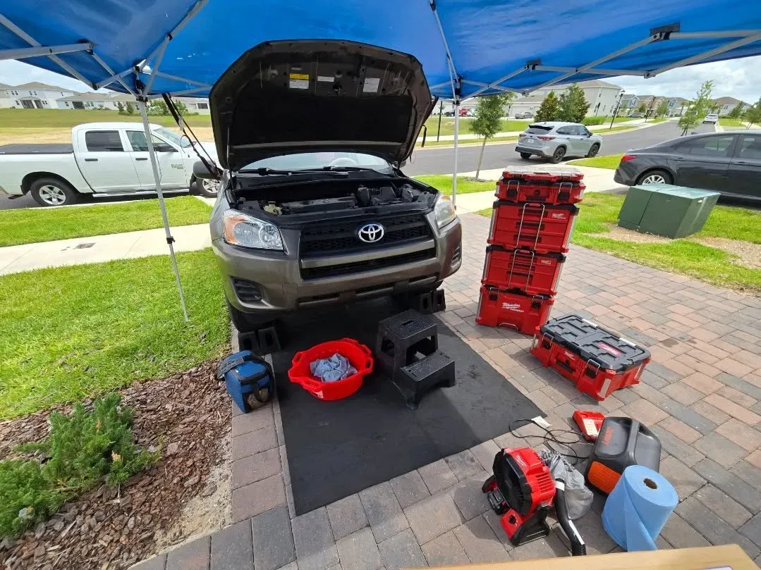 Professional mobile mechanic setup with canopy and organized tools in a driveway